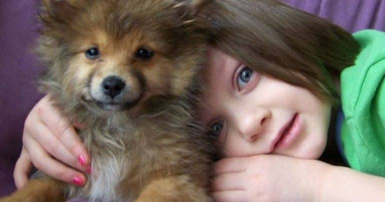 child snuggling with dog