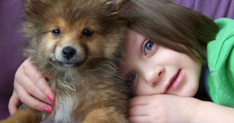 child snuggling with dog